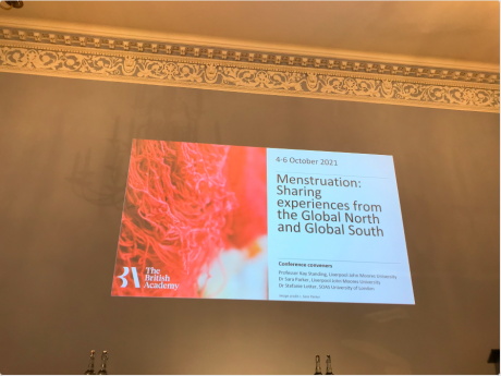 high ceilinged wall with powerpoint slide projected onto it. Slide reads The British Academy, 4-6 October 2021, Menstruation: sharing experiences from the global north and global south', conference conveners: professor kay standing, liverpool john moores university, dr sara parker, liverpool john moores university, dr stefanie lotter, SOAS