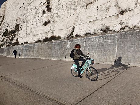 Astrid Blystad smiling, stood with a Brighton Bike on the Coastal path