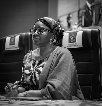  Juliet Ibekaku-Nwagwu sat at a conference with 'Founder/ED, African Centre' on the headrest of her chair. Photo in black and white.