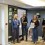 Group of people listening to SSRP co-Director John Thompson while standing in the exhibition space