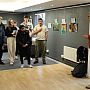 Group of people listening to SSRP member Filippo Osella while standing in the exhibition space