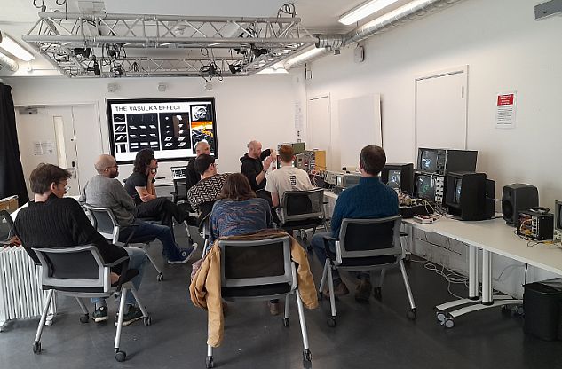 Group of people grouped around some computer screens during a workshop in the sussex humanities lab