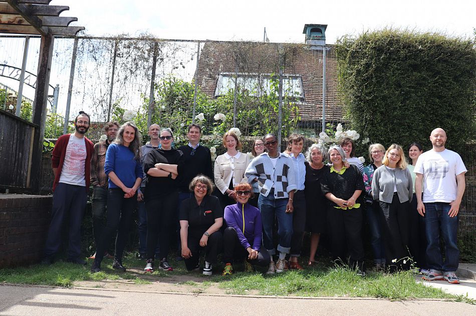 Picture of team in front of a house with roses and trees