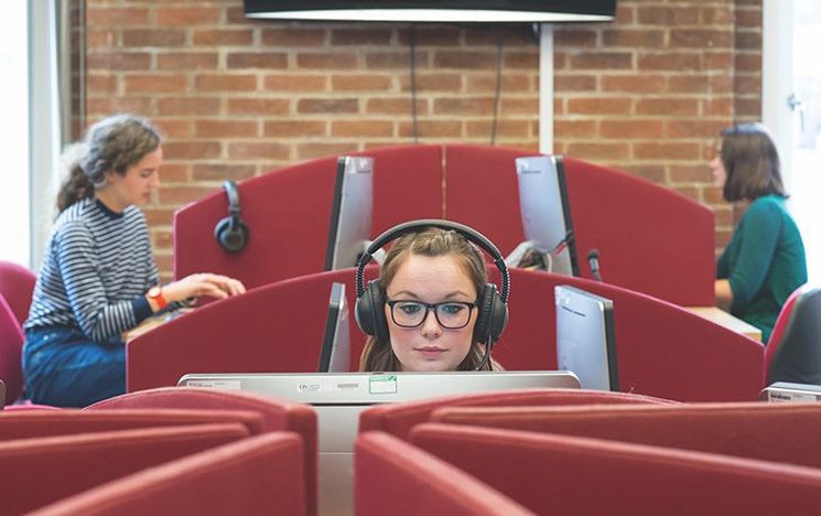 A female student studying at a computer pod