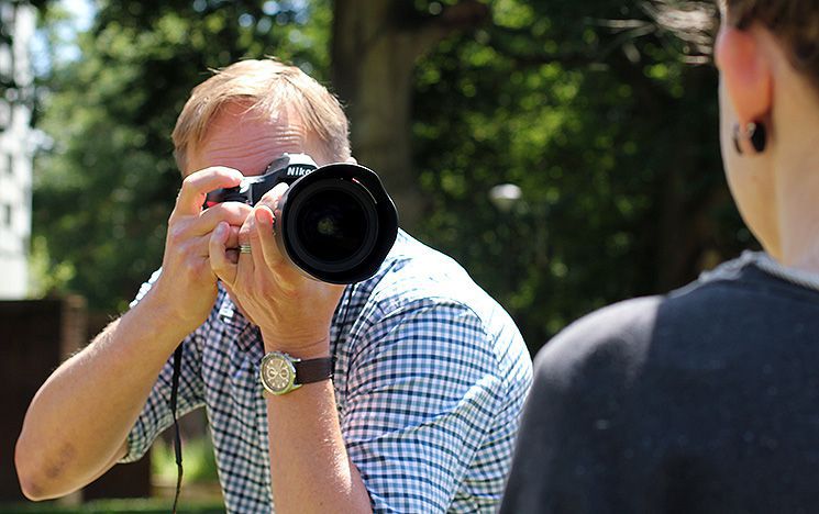 A Sussex photographer taking someone's picture on campus