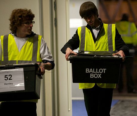 Two young men carrying ballot boxes