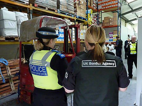 A policewoman and a UKBA official visit a factory