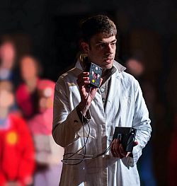 A man in a white coat holding the ghost detector