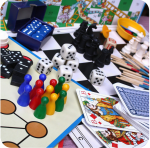A photo of various board games, including playing cards, dice, chess and checkers.