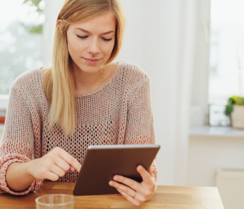 A woman reading a newsletter on an iPad