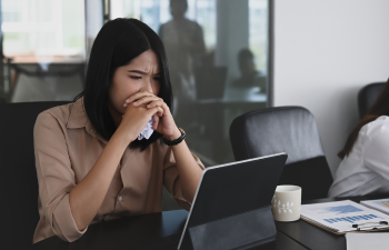 A young woman looking anxious while reading something on a tablet