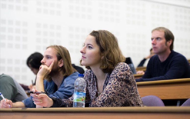 Post Graduate students sat in a lecture theatre learning