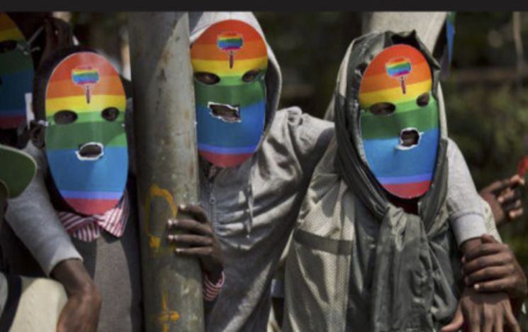 3 people wearing masks with rainbow decoration