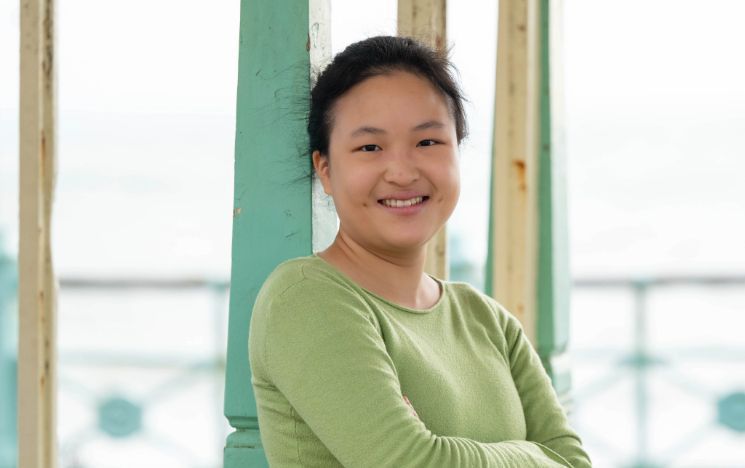 An international student smiles on Brighton Palace Pier