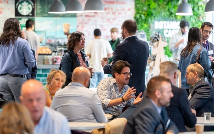 Groups of business people sitting and standing in conversation with eachother in Botanical cafe in Jubilee Building