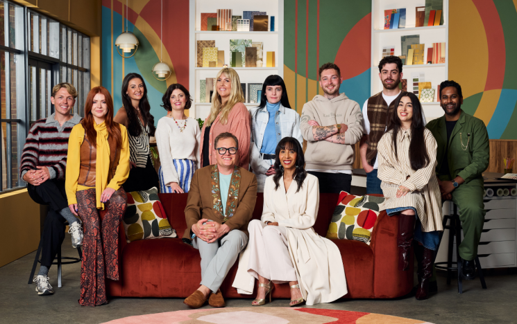 A group of people sit together and smile. They are the group of people who work on the television show - Interior Design Masters.