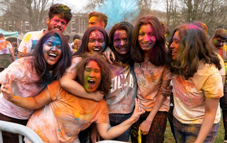 Students posing covered in coloured powder