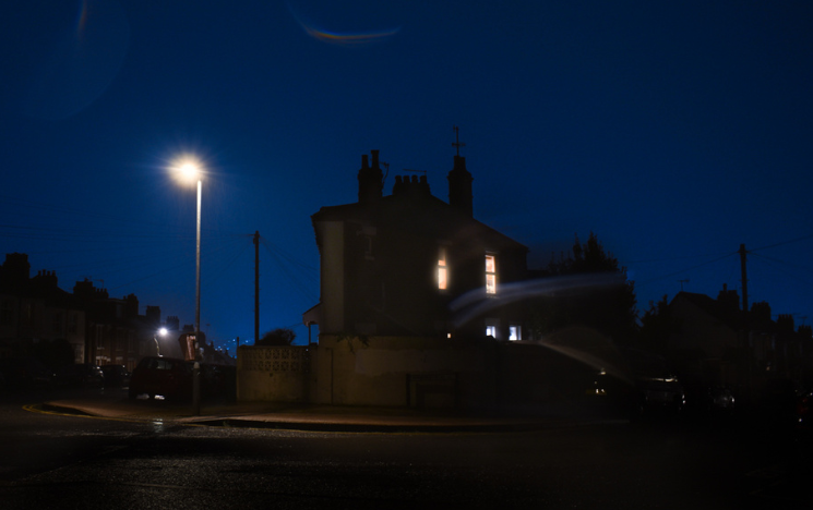 A house by an empty road at twilight