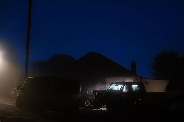 Cars parked outside a building on a foggy night