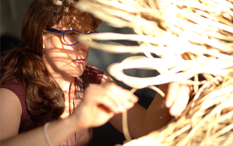 A woman in glasses touching lights.
