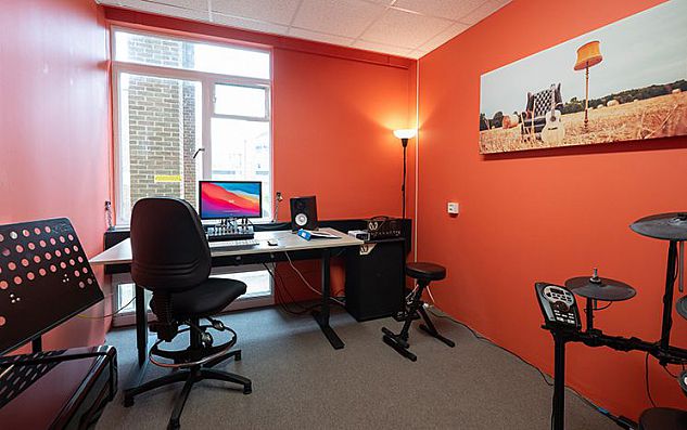 A studio with a desk and drums