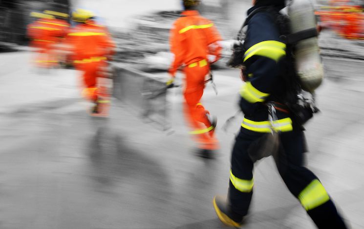 Firefighters running towards an emergency.