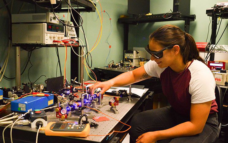 PhD student Poppy Joshi with blue laser