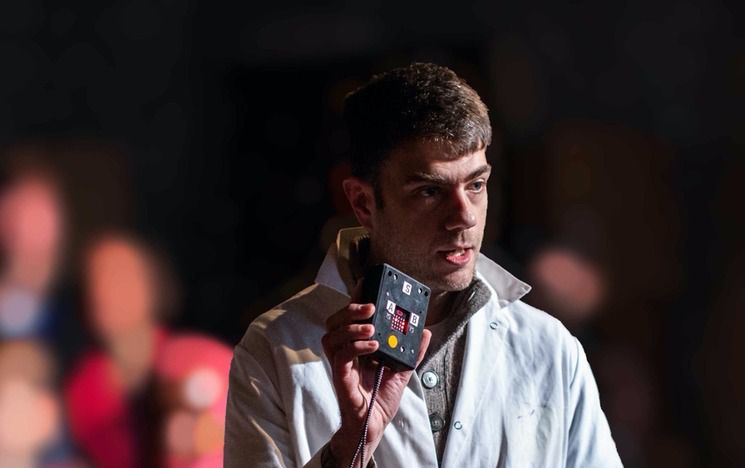 Man in white coat holds up ghost hunting machine