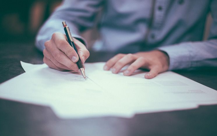 Man writing on paper - Photo by Scott Graham on Unsplash