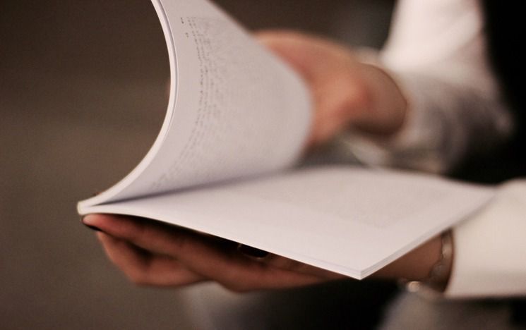 Man's hands holding piles of paper Photo by Andisheh A on Unsplash