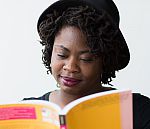 Profile image of student Denise reading a book to help you identify with other students like them that maybe having difficulties