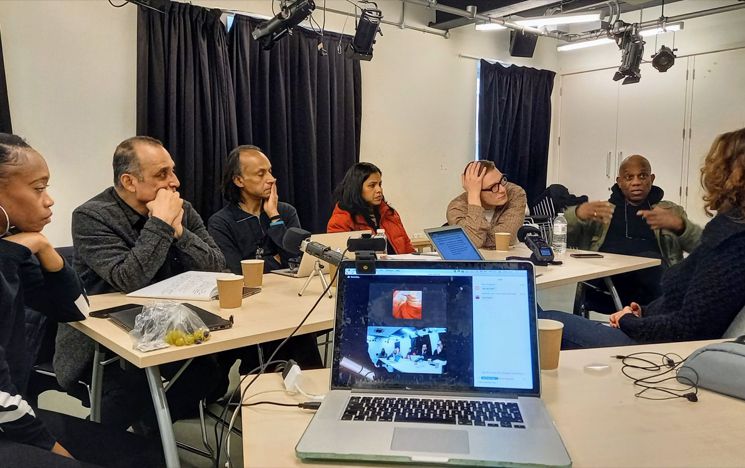 Actors at a table with computer on zoom call