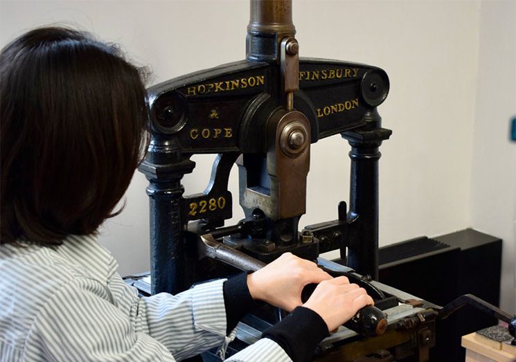 Photo of person using an old fashioned printpress