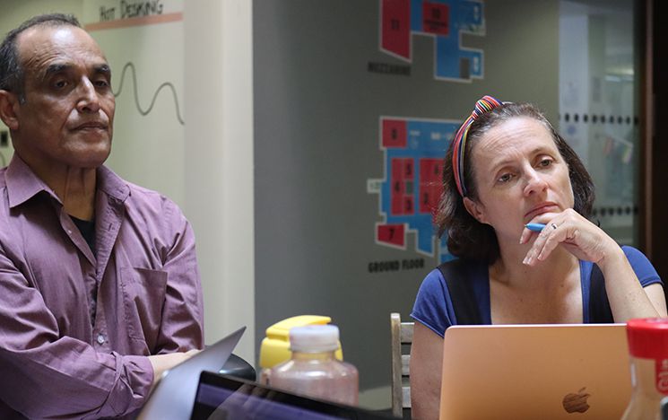 An actor and the director listening intently to ongoing discussions in the workshop round table