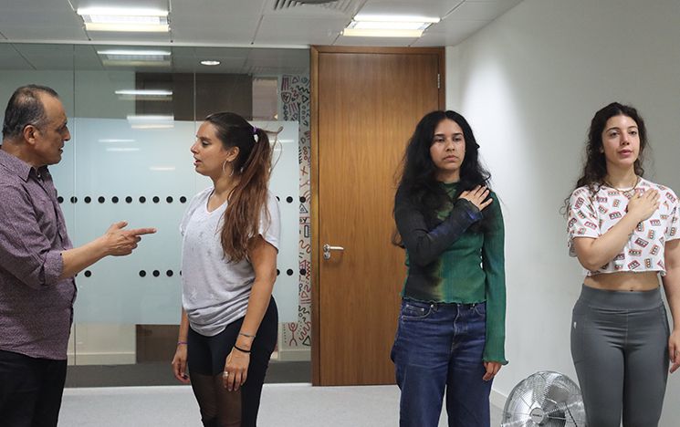 Actors in pairs enacting two parallel scenes based on different themes from the 1984 carnage
