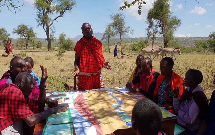 A group of people working on the African land degradation project discuss the project at a table.