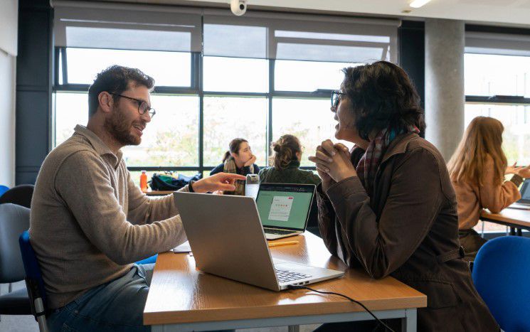 Two students engage in conversation in a seminar