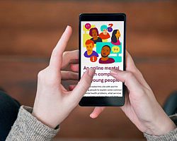 A phone is being held with only two hands visible. The screen displays an app interface for online mental health support.