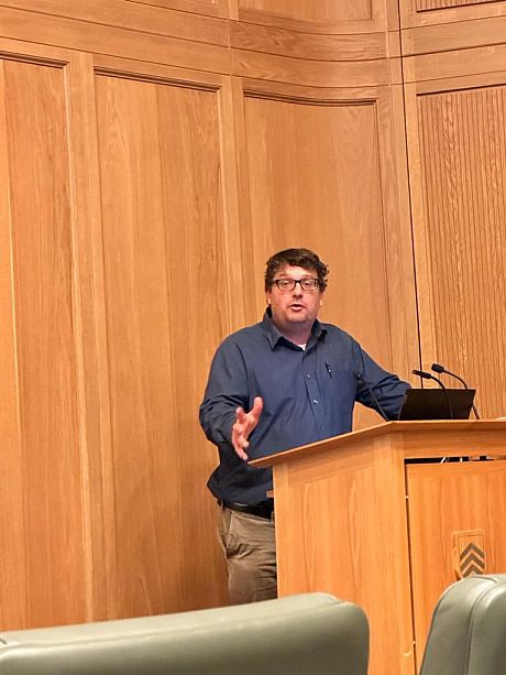 Prof. Magnus Marsden stood at a podium, giving a presentation at Oxford