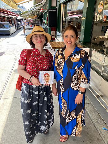 Vera sharing a copy of the exhibition booklet with a member of one of the communities involved in the project (Vienna)