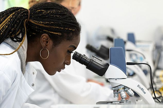 Student looking through a microscope in a lab