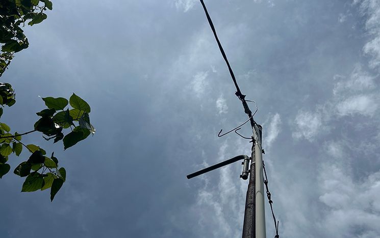 Cables attached to a pole with sky in the background