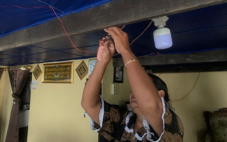 Woman connecting lighting cables on ceiling