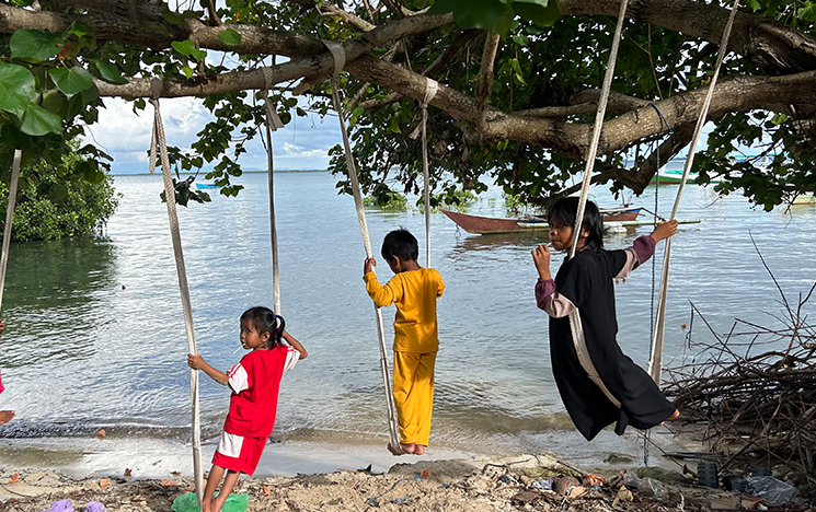 Children playing on the beach in Biyowasa