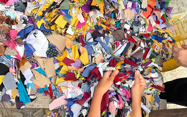 Hands sorting through colourful scraps of fabric