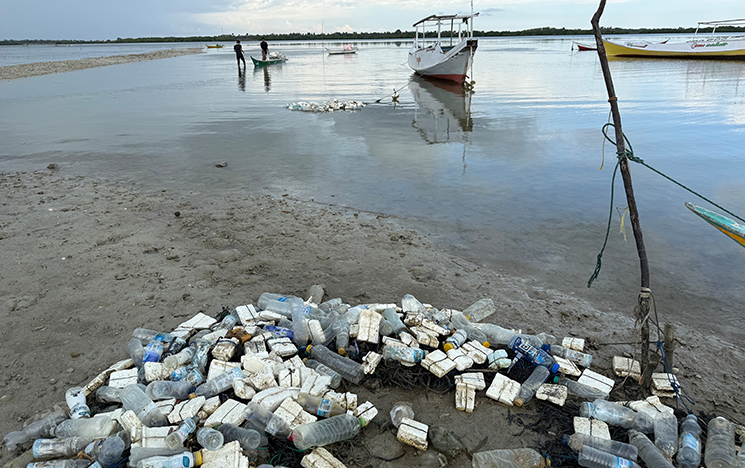 Plastic bottles on a rope with the sea behind.