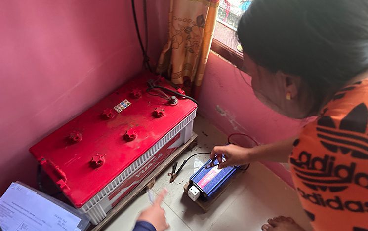 Woman bending over to touch a battery on the floor