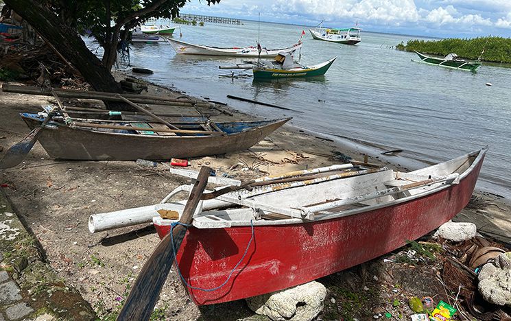 Boats resting on the shore with other boats at sea