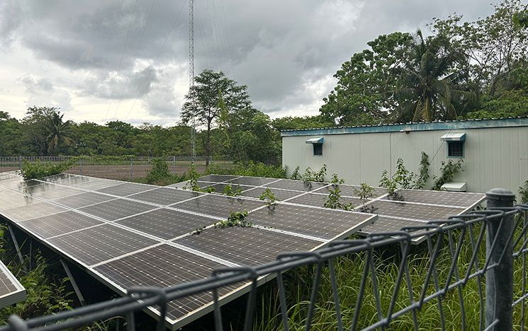 Solar panels on the ground next to a small building