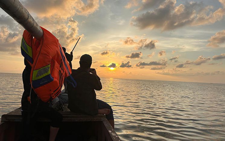 Sunset from a boat with figure looking out